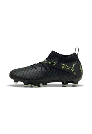 Crampons de football noirs avec une tige synthétique texturée. Présente des accents verts, un col coupé bas et des crampons moulés pour la traction.