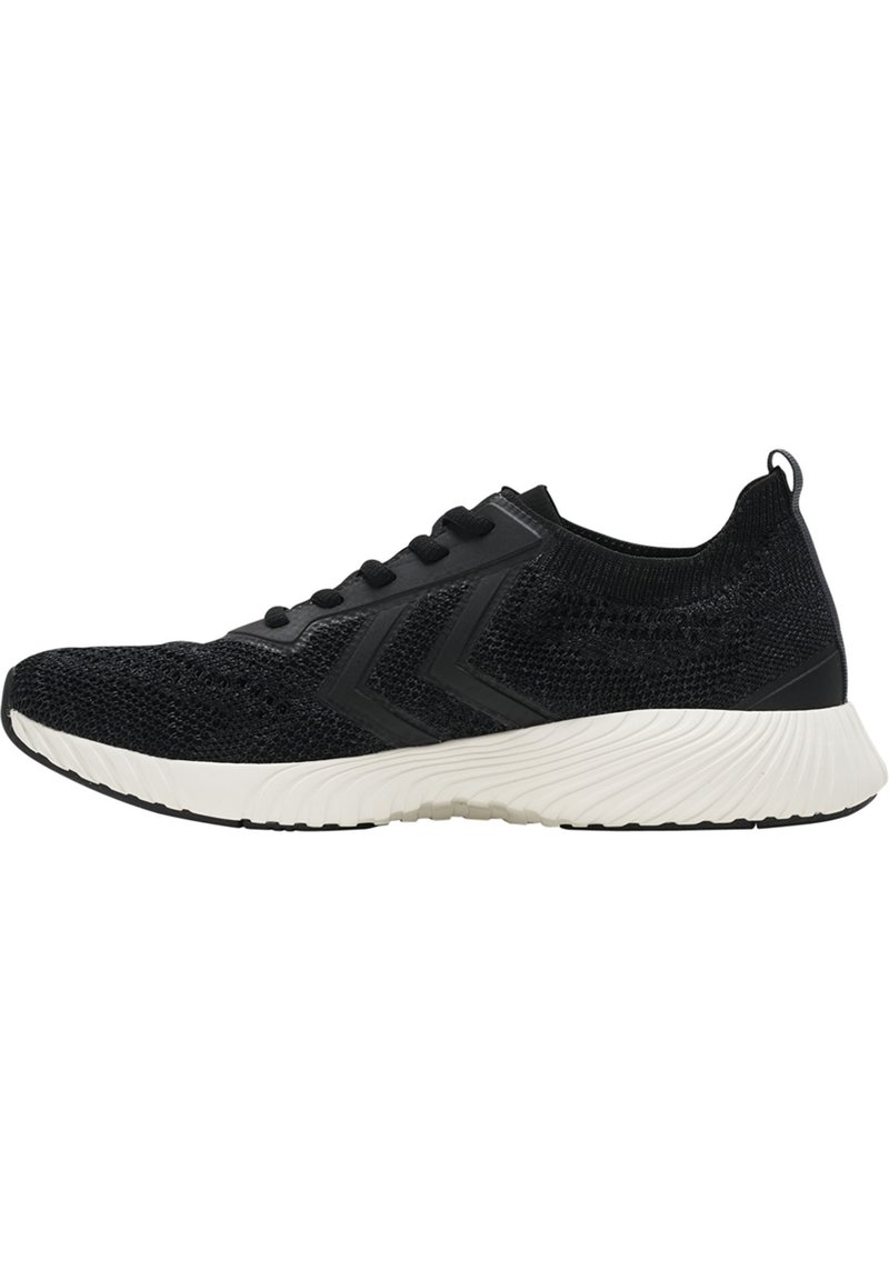 Czarne dzianinowe buty sportowe z teksturowaną powierzchnią, z czarnymi sznurowadłami, białą podeszwą środkową i akcentami w kształcie chevronu po bokach.