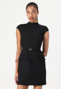 Robe noire avec un col haut, des manches courtes, une taille ceinturée et deux poches avant. Tissu lisse avec une silhouette ajustée.