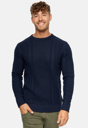 Navy blue knit sweater featuring a textured cable pattern with ribbed cuffs and hem. Fabric appears warm and tightly woven.