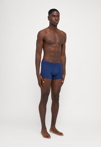 Marineblaue Stretchbaumwoll-Boxershorts mit körperbetontem Schnitt und glatter Textur. Verfügt über einen bequemen Bund und eine vordere Tasche.