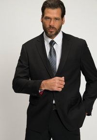 Zwarte colbert met notch-lapels, gecombineerd met een witte shirt en een grijs gestreepte stropdas. Het pak heeft een getailleerd ontwerp en een subtiele pochette.