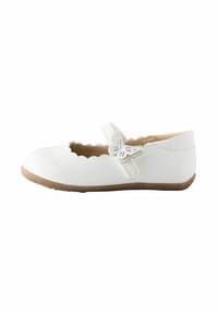 Zapato de charol blanco para ni�ños estilo Mary Jane con bordes con volante, detalle de mariposa en la correa y suela de goma marrón claro, mostrado en vista lateral.