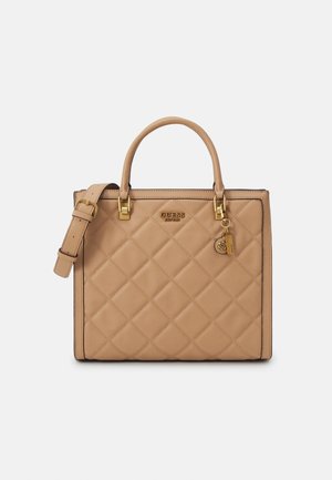 Sac à main matelassé beige avec poignées supérieures, bandoulière réglable, quincaillerie dorée et breloque logo dorée décorative de Guess.
