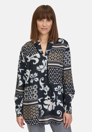 Langarmblouse met een mix van bloemen- en geometrische patronen in navy, beige en wit. Zachte stof met een relaxte pasvorm en V-hals.