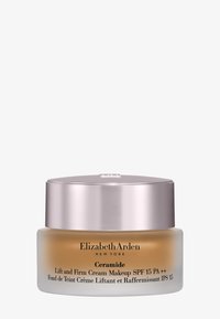 Crema de maquillaje Elizabeth Arden Ceramide Lift and Firm con SPF 15 en un frasco de vidrio esmerilado con tapa plateada.