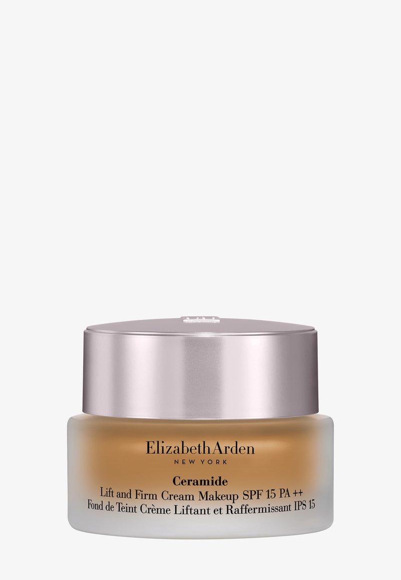 Crema de maquillaje Elizabeth Arden Ceramide Lift and Firm con SPF 15 en un frasco de vidrio esmerilado con tapa plateada.