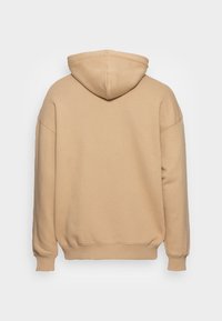 Beżowa bluza z kapturem na sznurki, w oversize'owym kroju, z prążkowanymi mankietami i dołem oraz miękkim, teksturowanym materiałem. Gładkie plecy bez elementów dekoracyjnych.