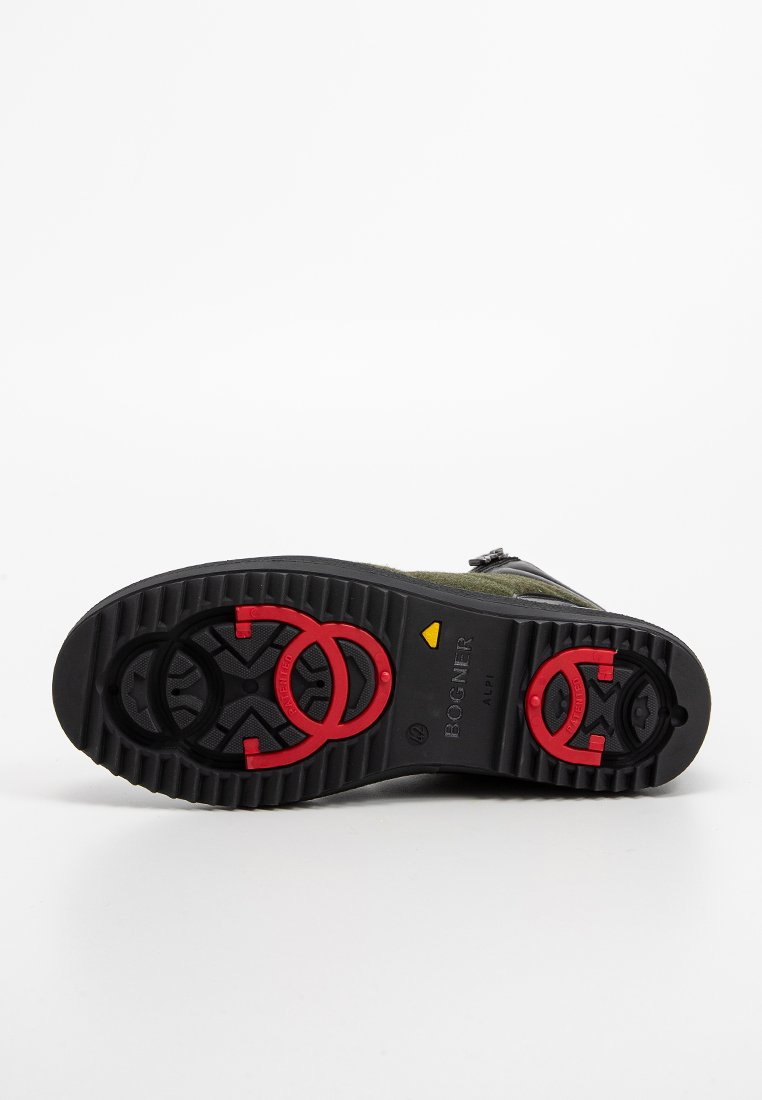 Schwarze Außensohle mit einem gerippten Muster, roten kreisförmigen Akzenten und gelbem Logodetail über dem Wort "BOGNER" und "ALPI."