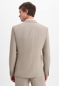 Helle beigefarbene Anzugjacke aus strukturiertem Stoff, mit taillierter Passform, einem Schlitz hinten und zwei Knöpfen am Ärmel.