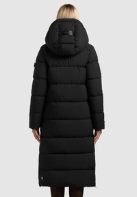 Manteau long matelassé noir avec capuche doublée et poignets côtelés. Présente un design matelassé, une fermeture éclair frontale et un détail de logo discret près de l'ourlet.