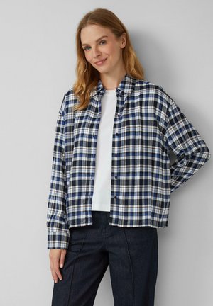 Blau-weiße kariertes Hemd mit langen Ärmeln, Knopfverschluss und einem lässigen Schnitt, kombiniert mit einem weißen T-Shirt und dunklen Hosen.