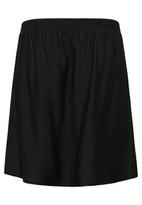 Svart kjol med elastisk midja, tillverkad av ett lätt tyg. Har en plisserad design och en fåll som faller strax ovanför knäet.