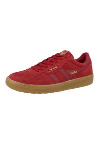 Baskets en daim rouge avec fermeture à lacets, semelle extérieure en caoutchouc gomme et accents en logo doré. Présente deux rayures latérales d'un rouge plus foncé.