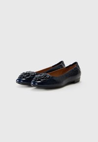 Mocasini din piele lăcuită bleumarin, cu vârful rotund, având un accent texturat sub formă de floare pe partea superioară și un toc jos, plat.