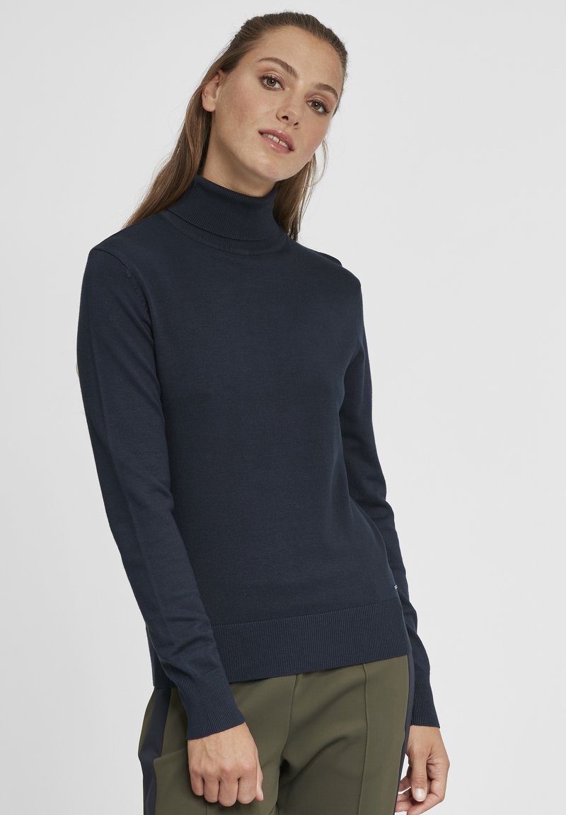 Maglione a collo alto di un blu scuro navy con maniche lunghe, colletto e orlo a coste, realizzato in morbido materiale lavorato a maglia; presenta una silhouette aderente.