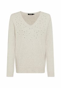 Hellbeiger Pullover mit langen Ärmeln, V-Ausschnitt und vorne mit verstreuten silbernen Nieten verziert. Gerippter Saum und Bündchen.