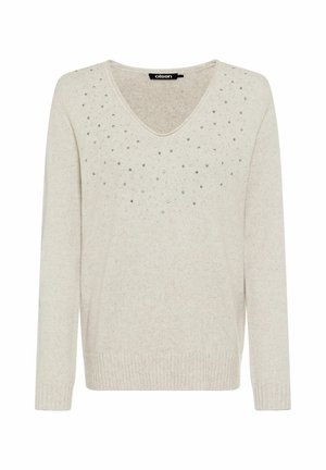 Maglione color beige chiaro con maniche lunghe, scollo a V e decorato con borchie argento sparse sul pannello frontale. Orlo e polsini a coste.