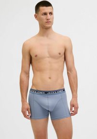 Férfi kék boxer alsónadrág kontrasztos fekete derékkal, amelyen a "JACK & JONES" logó található; puha, sima textúra és testhezálló szabás.