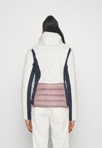 Dunjakke med hvit og marineblå design, med et kviltet rosa bakpanel. Med hette, kontrastfargede sidestykker og glatt tekstur.