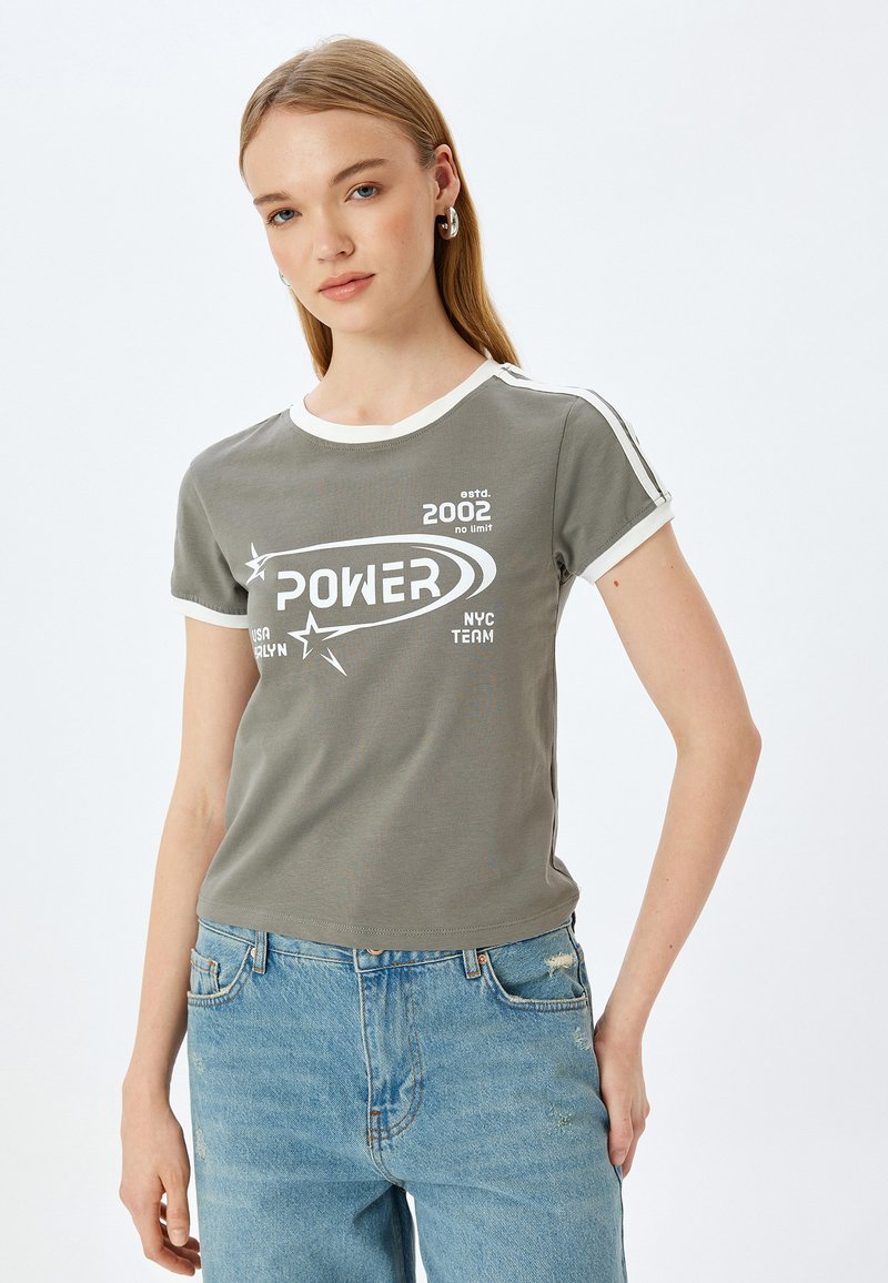 Olijfgroene t-shirt met korte mouwen en witte accenten, met de grafische tekst "POWER". Zachte stof, ronde hals, smal model.