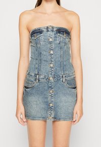 Džínové šaty bez ramínek, světle modré, s knoflíkovou přední částí, dvěma náprsními kapsami, přiléhavým korzetem a rovnou mini sukní, strukturovaná tkanina.