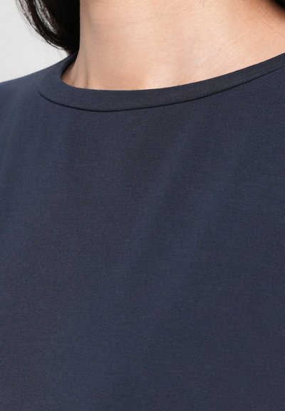 T-shirt blu navy con una texture liscia e morbida. Presenta un classico scollo rotondo e cuciture minime per un aspetto pulito.