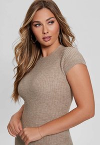 Beige ribbed-knit short sleeve top featuring a crew neckline and fitted silhouette, with a soft texture and subtle detailing.