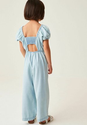Combinaison bleu clair avec manches bouffantes, dos smocké et découpe en trou de clé. Dotée de jambes larges et d'une texture en denim doux. Chaussures non incluses.