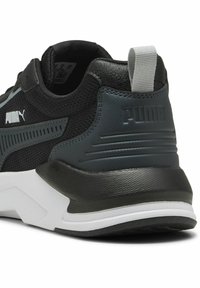 Scarpa sportiva nera e grigia scura con tomaia in rete, suola in gomma, collo imbottito e un logo Puma bianco ben visibile sul lato.