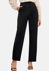 Pantaloni neri su misura con design a gamba dritta, realizzati in un tessuto leggero e morbido, caratterizzati da pieghe frontali e tasche laterali.