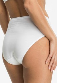 Weiße Baumwoll-Hochschnittunterwäsche mit glatter Textur und minimaler Naht, die Rückendeckung bietet und die Kurven des Körpers betont.