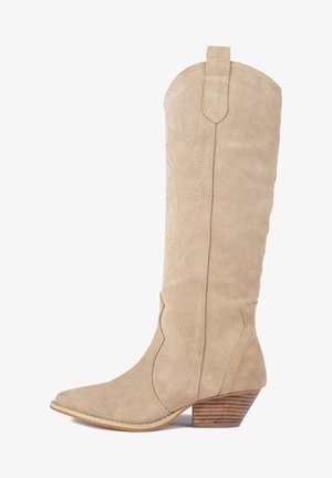 Beige nahka cowboy-kengät, joissa on terävä kärki, koristeellinen ompelu ja pinottu puinen korko. Korkeus ulottuu polven keskelle.