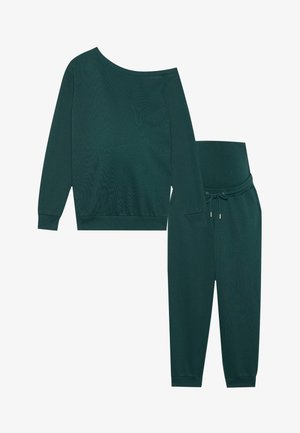 Donkergroene lounge-outfitset met een licht off-shoulder lange mouw top en tapered broek met trekkoord in de taille en geribbelde boorden.