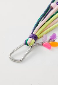 Fermoir avec des cordons multicolores en vert, violet, rose et jaune ; il présente de petites perles en plastique colorées en rose, violet et orange.