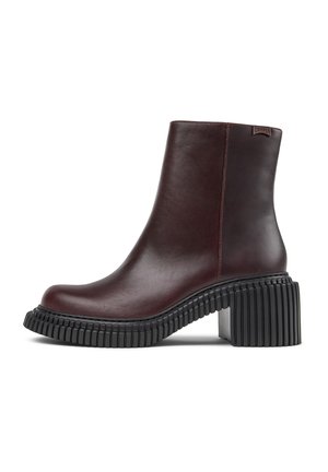 Mørkebrune lær ankle boots med kraftig sort såle og blokk hæl, med et lite merketag nær den øverste kanten.