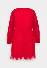 Robe rouge avec une surface texturée, présentant des manches longues en transparence, une taille cintrée et une jupe évasée tombant juste au-dessus du genou. Fermeture éclair au dos classique.