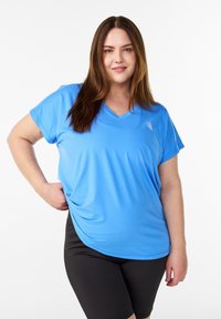 Hellblaues kurzärmeliges Sportoberteil mit V-Ausschnitt, gefertigt aus atmungsaktivem Stoff, kombiniert mit schwarzen Shorts.