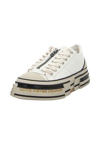 Klobige weiße Sneaker mit einer strukturierten Oberseite, schwarzer und beiger Plateausohle, seitlichem Reißverschluss und dem Schriftzug "LOVE NEVER CHANGES".