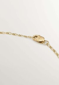 Cadena de oro con eslabones en un diseño retorcido, que presenta un cierre pulido. Su textura suave y acabado brillante realzan su apariencia.