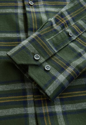 Groen geruit flanellen overhemd met blauwe en gele accenten. Beschikt over een knoopsluiting op de kraag en twee knopen op de manchetten. Zachte, gestructureerde stof.