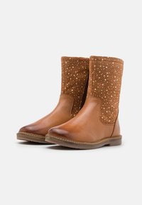 Bottines en cuir marron avec finition lisse, partie supérieure en tissu brun moucheté contrastant, bout arrondi et semelle en caoutchouc robuste.
