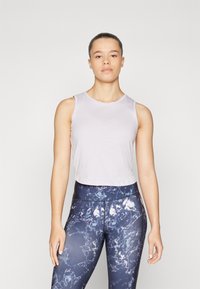 Svetloružový cropped top s okrúhlym výstrihom v kombinácii s tmavomodrými legínami s mramorovým vzorom. Hladká textúra a priliehavý strih.