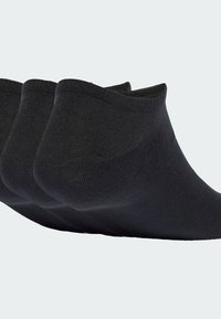 Čierne členkové ponožky s hladkou, elastickou textúrou, s vystuženou pätou a rebrovaným manžetom. Tri páry zobrazené v poradí.