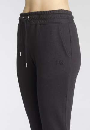 Schwarze Jogginghose mit elastischem Bündchen und Kordelzug; verfügt über Taschen und ein dezentes gesticktes Logo "H.I.S." am Bein.