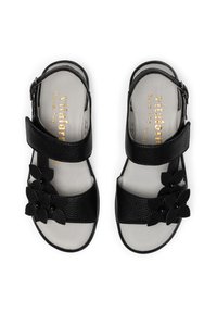 Schwarze Ledersandalen mit zwei verstellbaren Riemen, flachen Sohlen und dekorativen Stoffblumen an der Außenseite. Goldene Markenkennzeichnung im Inneren.