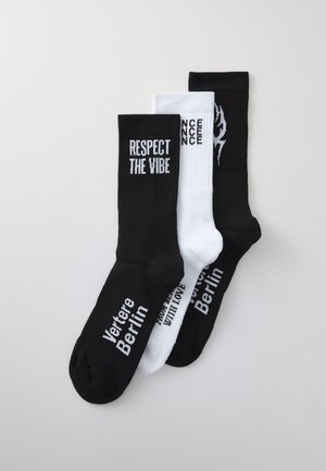 Three pairs of socks: black with white text "RESPECT THE VIBE," white with black text, and black with white logo, cotton blend, mid-calf length.