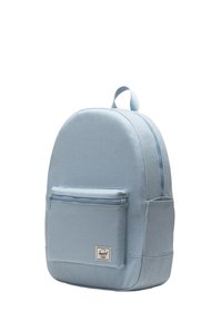 Sac à dos bleu clair en tissu durable, proposant une forme arrondie, une poche zippée à l'avant et une poignée de transport supérieure.
