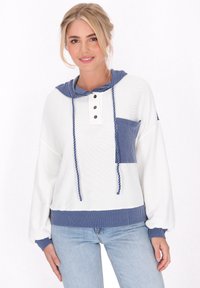 Felpa bianca in cotone con accenti a strisce blu. Presenta un cappuccio con lacci, tre bottoni e una tasca frontale. Maniche lunghe e ampie.