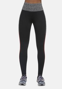 Czarne legginsy z wysokim stanem, z teksturowanym szarym pasem, dopasowany krój, czerwone paski po bokach oraz wzmocnione szwy. Połącz z butami sportowymi.